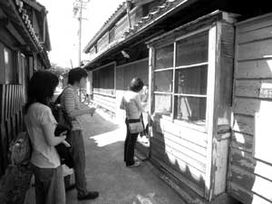 アートピクニックを楽しむ若いカップル(松岡徹（「大和屋観音」の前で）の写真