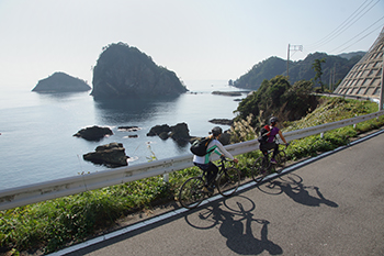 海岸線沿いの道路を疾走する自転車
