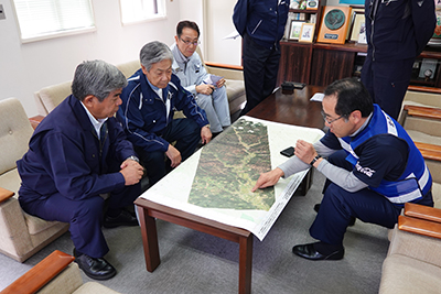 宮坂厚真町長（右）から説明を受ける荒木会長（左から2人目）と棚野北海道町村会長（左手前）